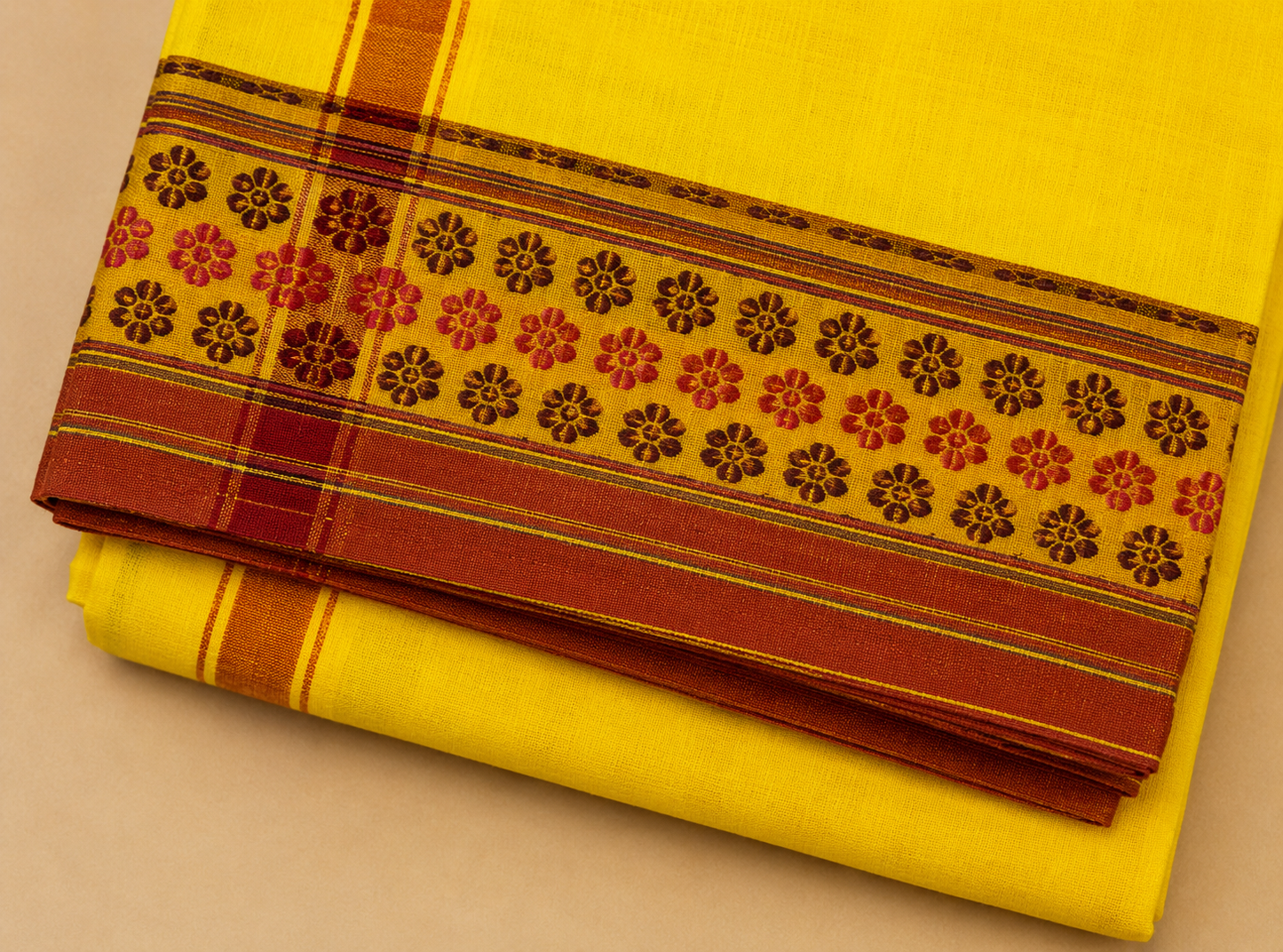Close up view of yellow cotton dhoti border design with traditional woven floral pattern