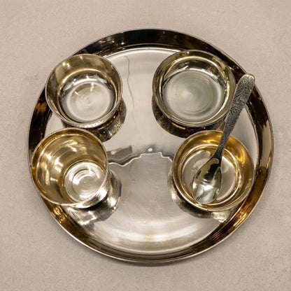 Silver tray with four compartments and a spoon on a beige background