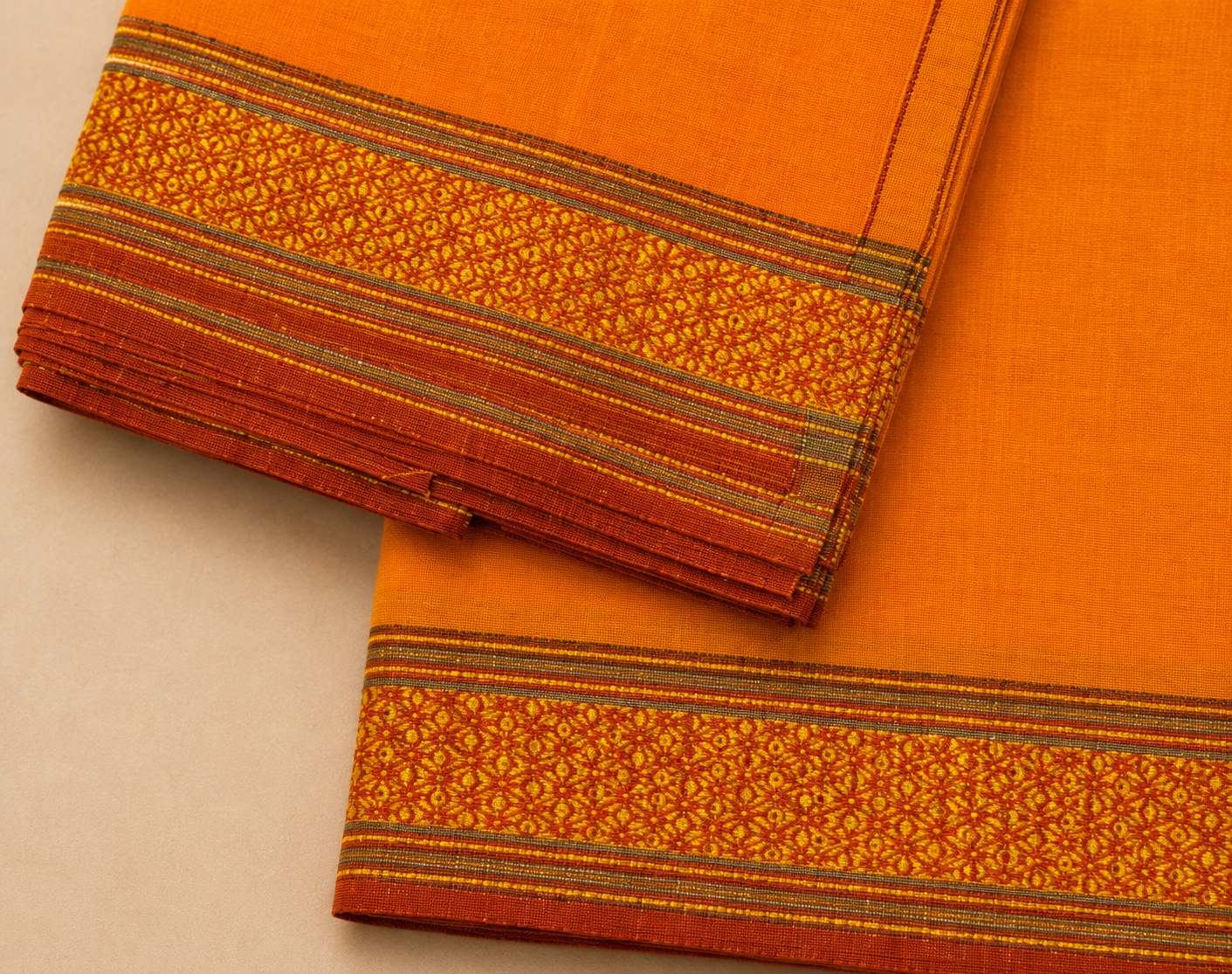 Close up zoom view of orange dhoti golden woven traditional border design