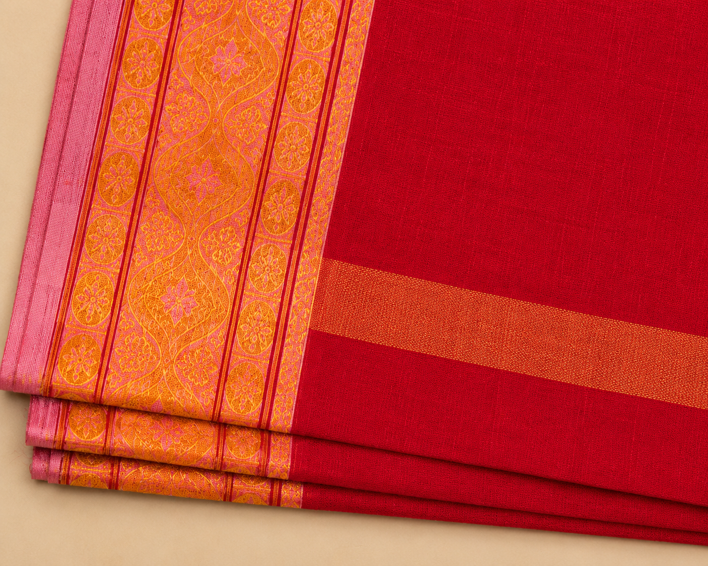 Close-up view of red cotton dhoti set with golden zari border and traditional woven design for men by Adhunik Swadeshi Bhandar