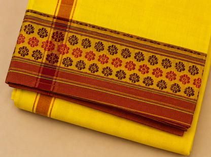 Close up view of yellow cotton dhoti border design with traditional woven floral pattern